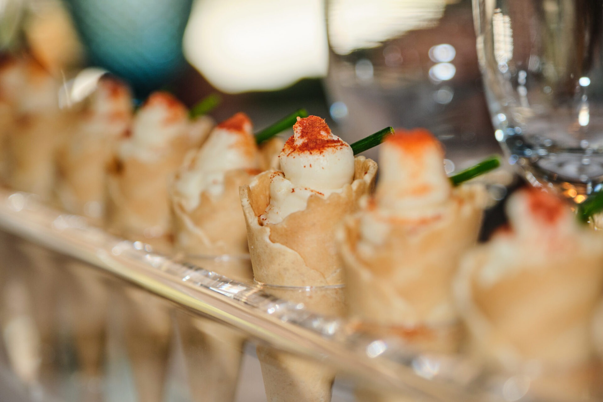 Detalle de aperitivos gourmet para bodas: cucuruchos salados rellenos de crema con presentación cuidada en bandeja de catering.