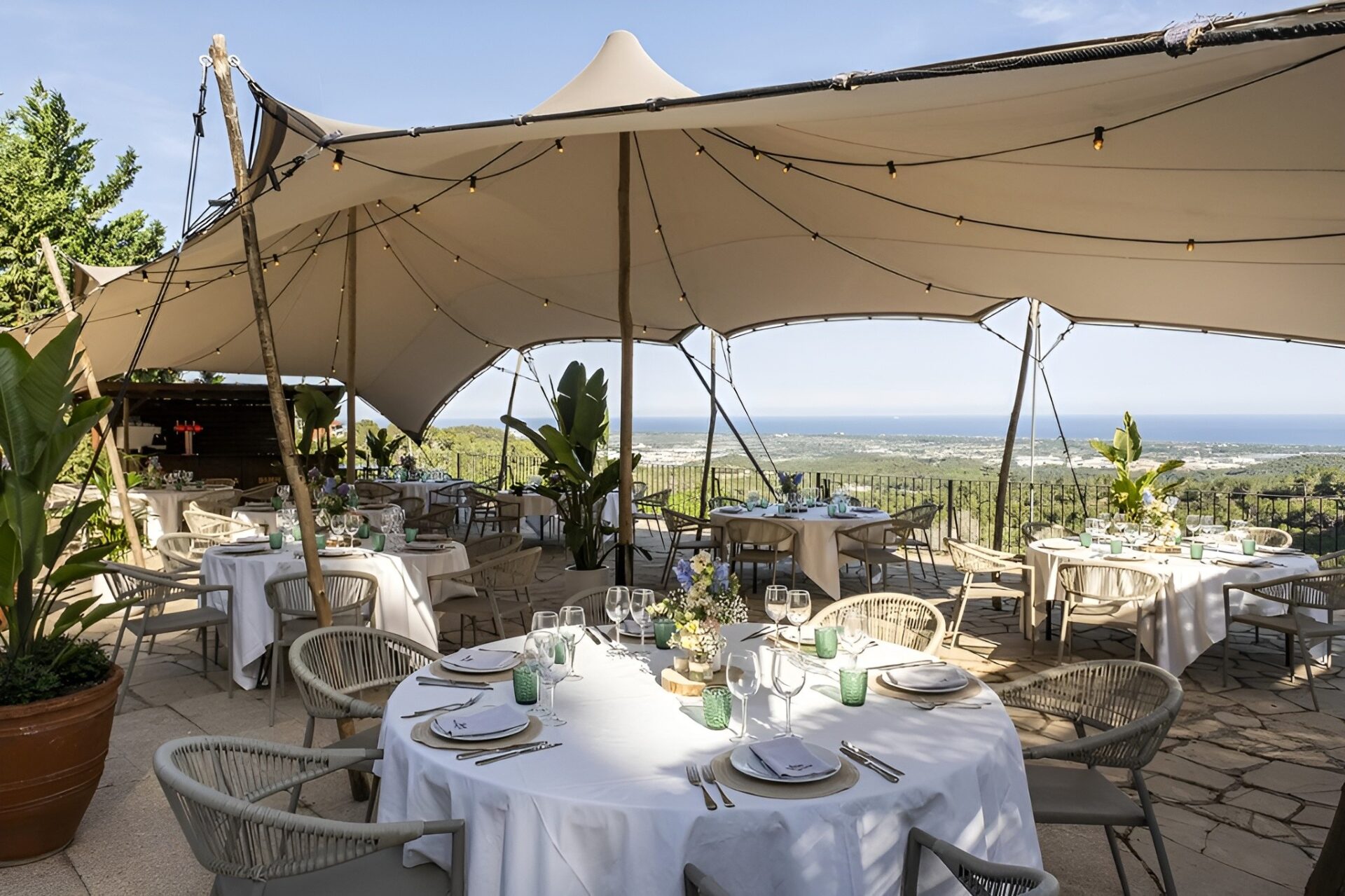 Montaje de mesas para banquete de boda bajo una carpa tensada con vistas panorámicas al mar en la terraza de Masia Solior, Gavá y Castelldefels.